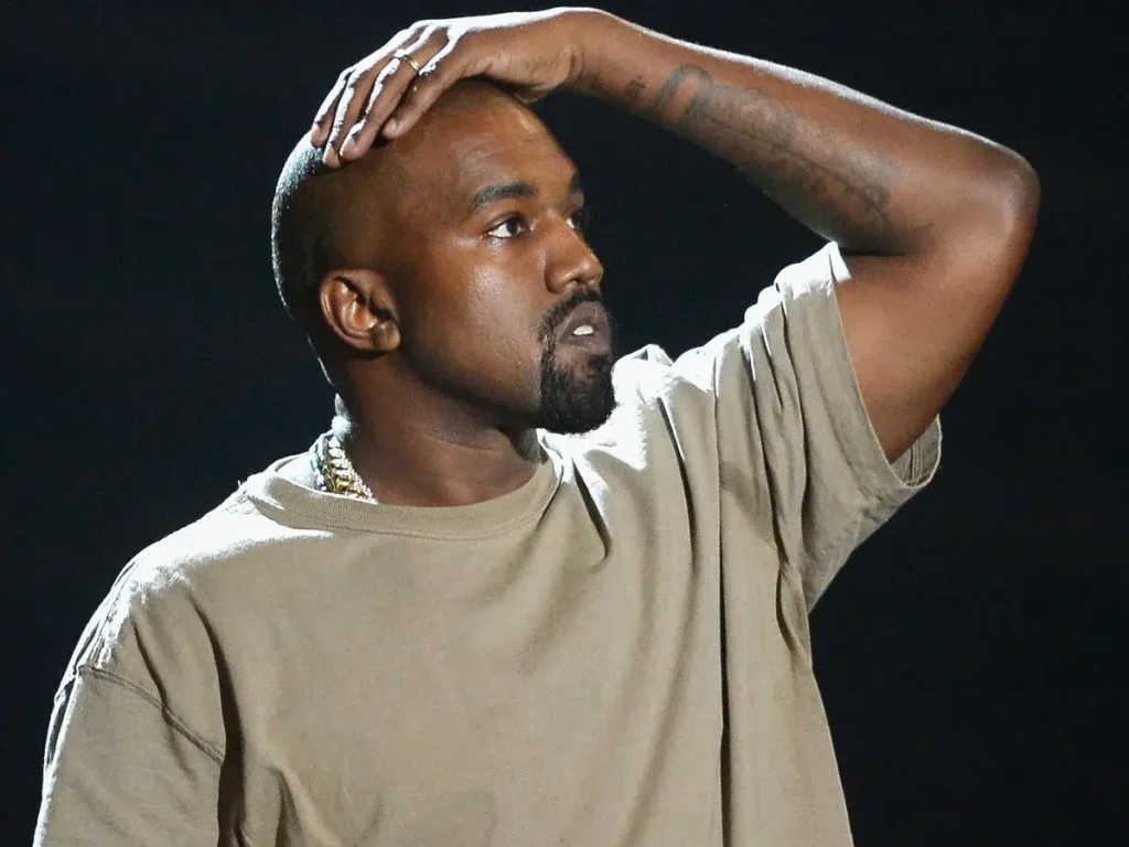 Kanye West with a hand on his head