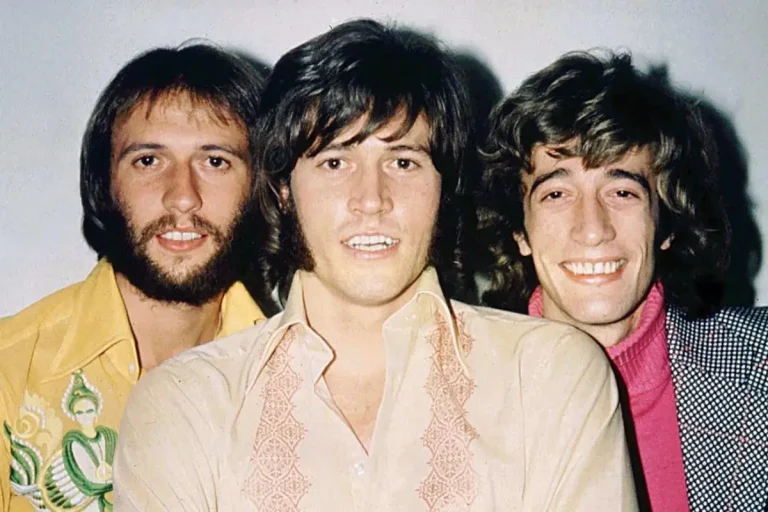 The Bee Gees posing side by side in a vintage color photograph.
