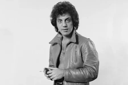 Billy Joel in a black-and-white portrait wearing a leather jacket.