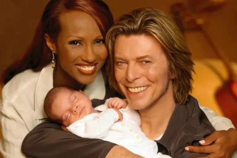 David and Iman holding a sleeping newborn close, conveying warmth, intimacy, and a quiet family moment.
