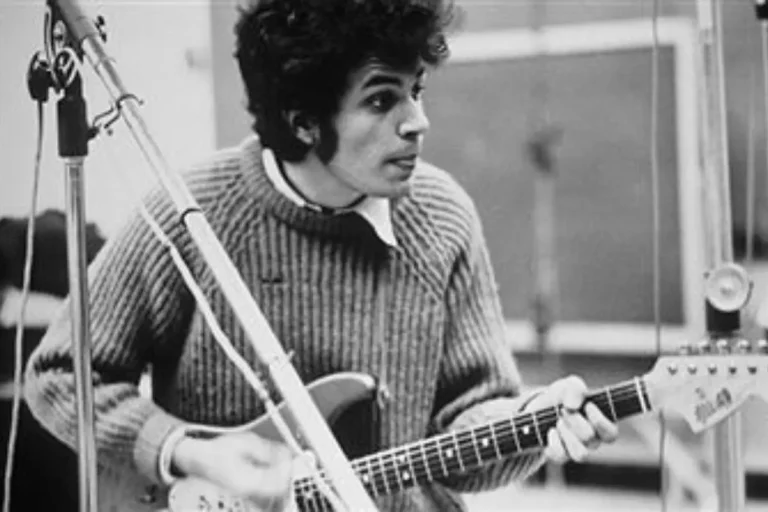 Dylan Built playing electric guitar in a recording studio.