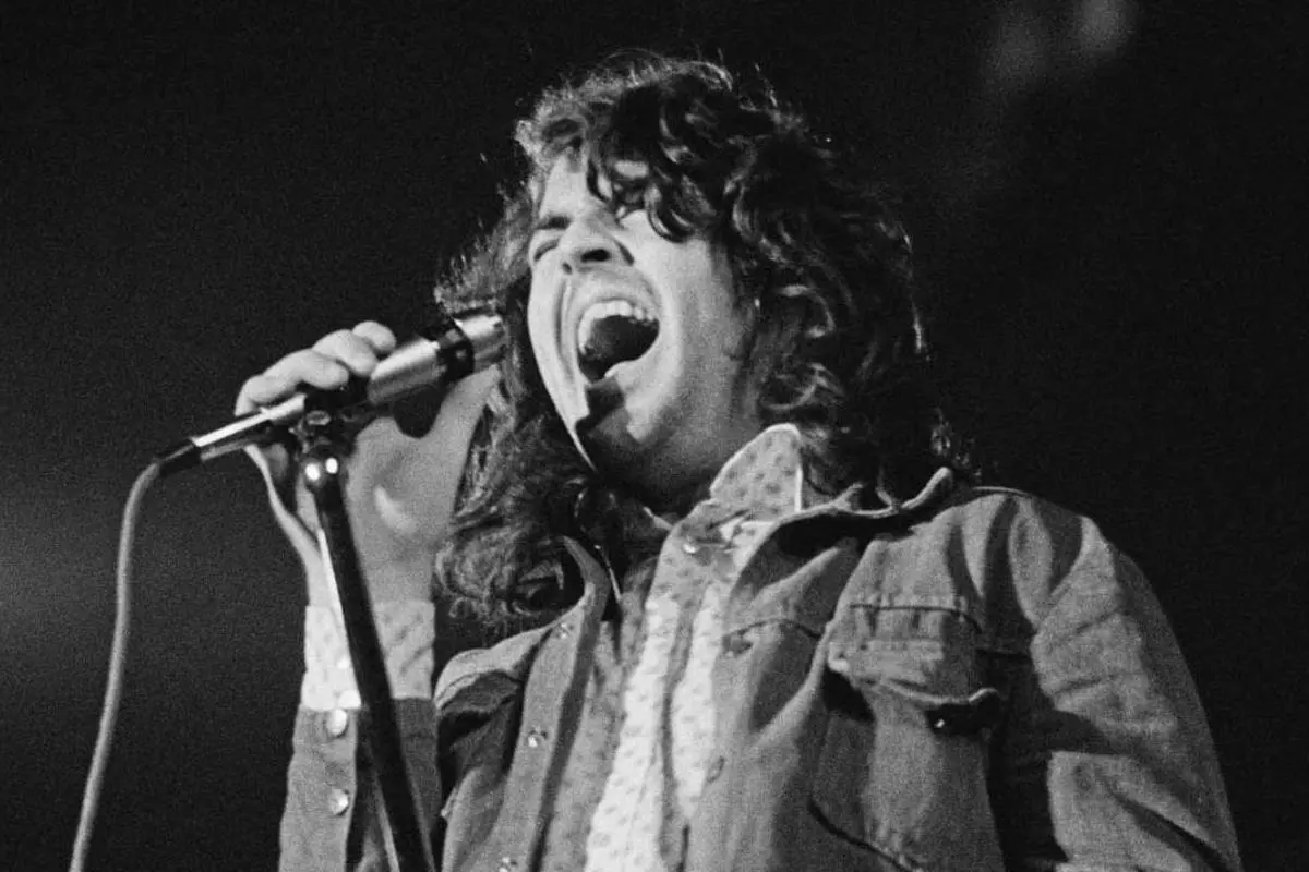 Ian Gillian vocalist singing passionately into a microphone on stage in a black-and-white photo.