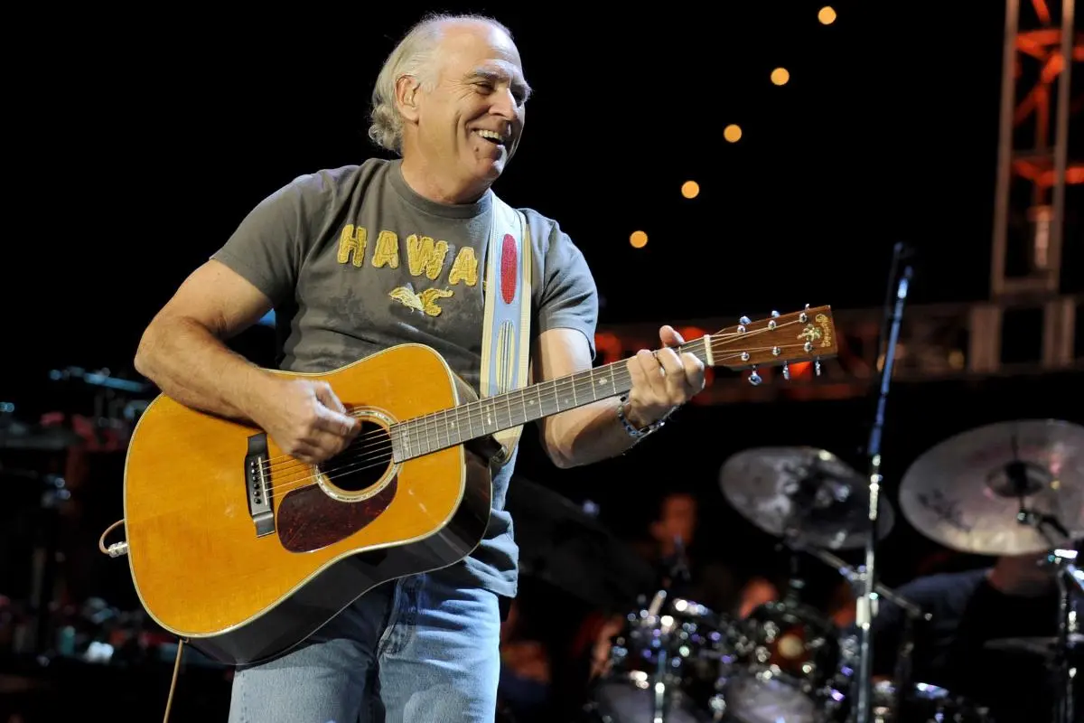 Jimmy Buffett playing guitar during a live concert performance.