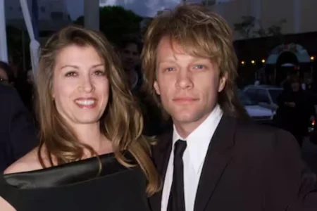 Jon Bon Jovi and Diane Lane dressed formally stand close together at an evening event, looking toward the camera.