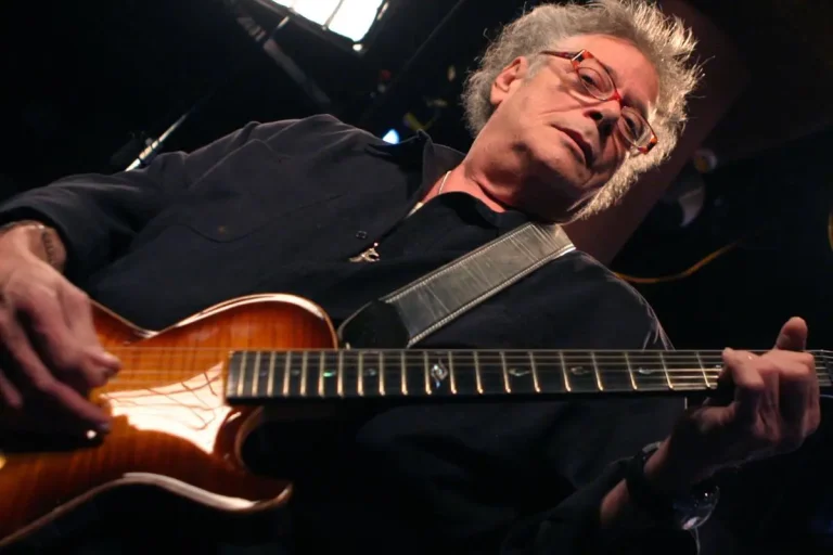 Leslie West performing live on stage, playing electric guitar.