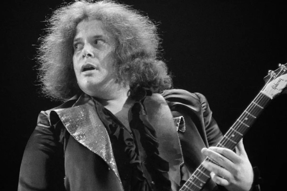 Leslie West singing and playing electric guitar during a live performance.