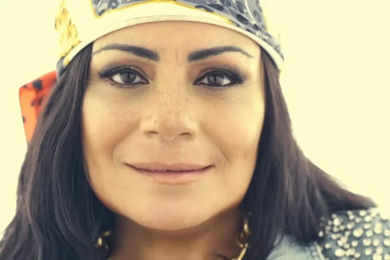 Lisa Velez (Lisa Lisa) wearing a patterned headscarf, close-up portrait with natural makeup and a calm expression.
