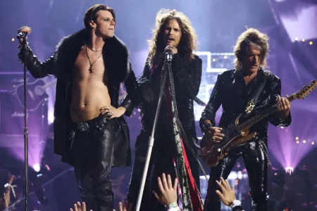 Nine Inch Nails on stage, frontman singing into a microphone with bandmates performing behind him.