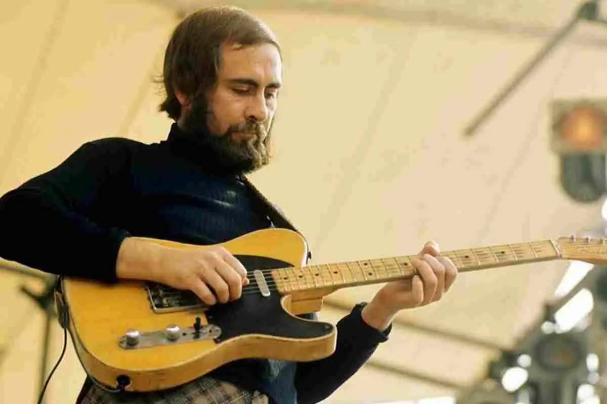 Roy Buchanan performing on stage, focused on playing an electric guitar.