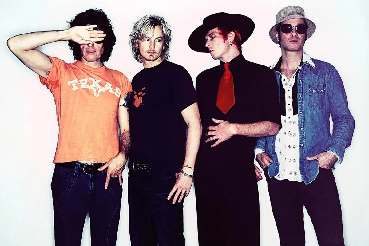 Stone Temple Pilots band members posing against a white background in casual, eclectic outfits.