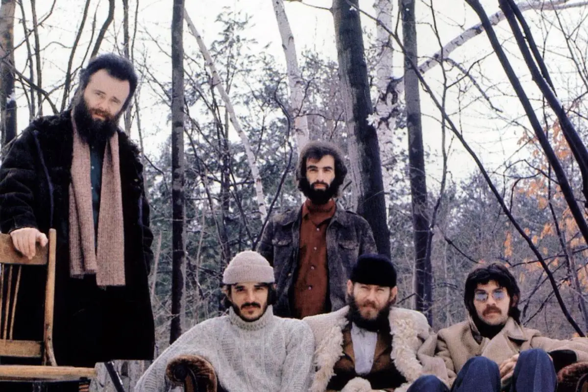 The Band gathered in a wooded setting wearing winter coats and hats.