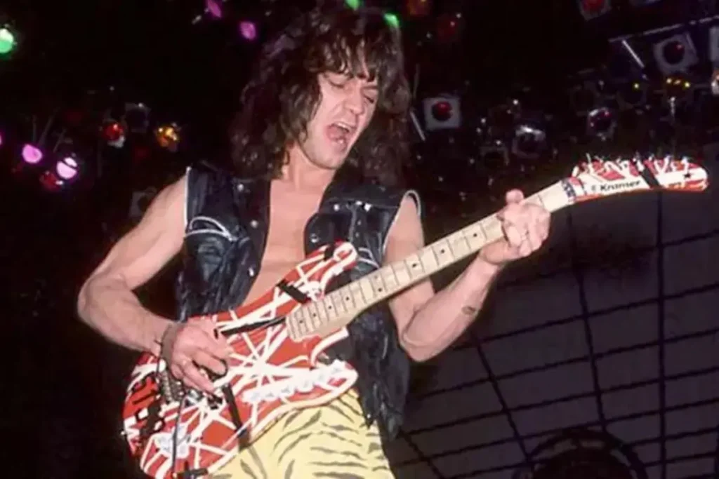 Van Halen plays a red-and-white striped electric guitar onstage.