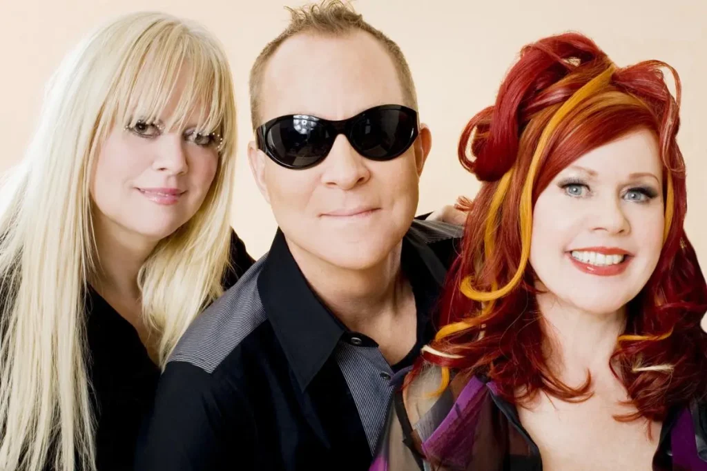 The B-52s pose closely together for a studio portrait.