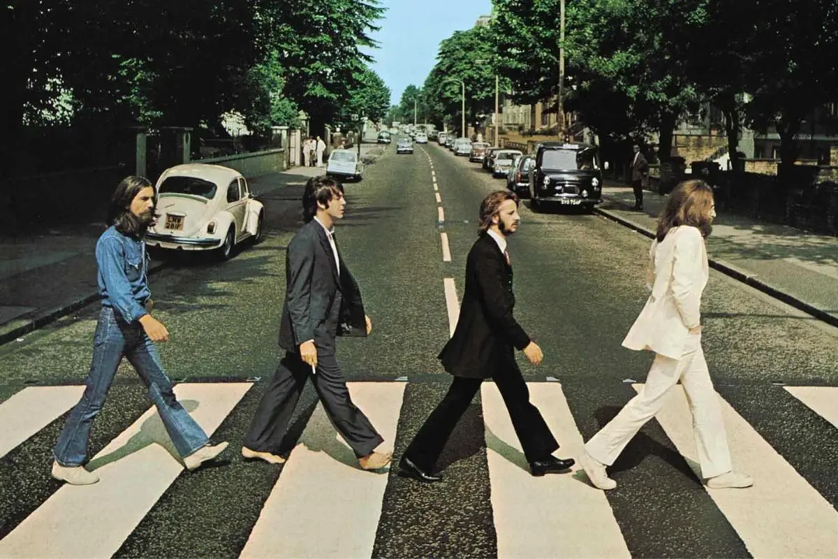 The Beatles walking in single file across the Abbey Road crosswalk.