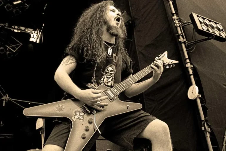 Dimebag Darrell performing onstage, shouting passionately while playing.