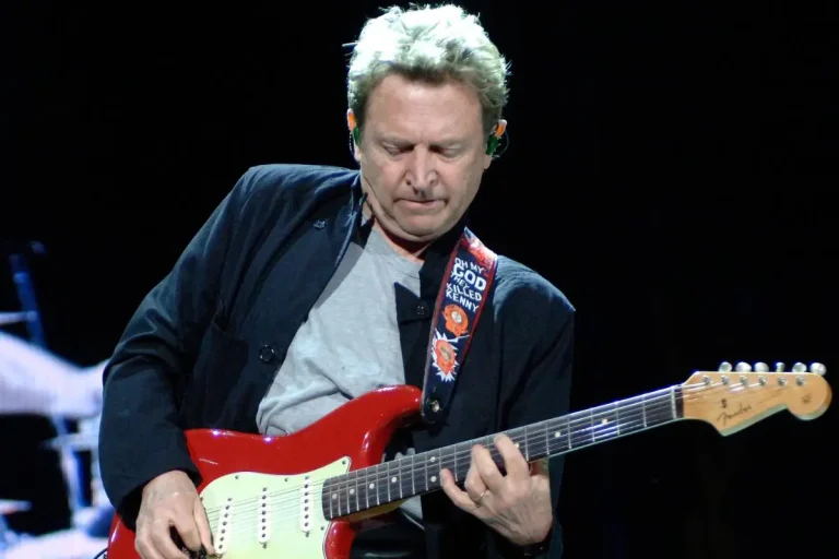 Jeff Healey plays a red Fender Stratocaster onstage, focused on his instrument.