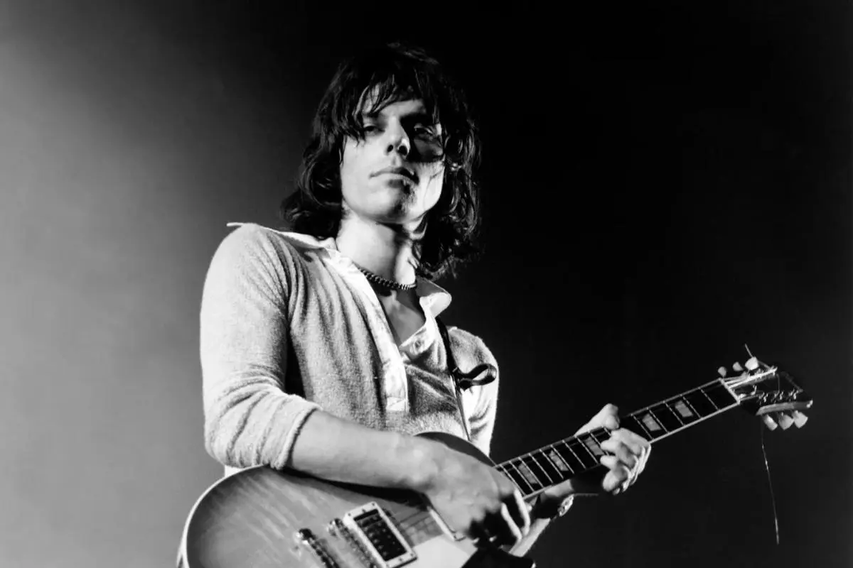 Jeff Beck performing on stage with electric guitar, black-and-white photo.