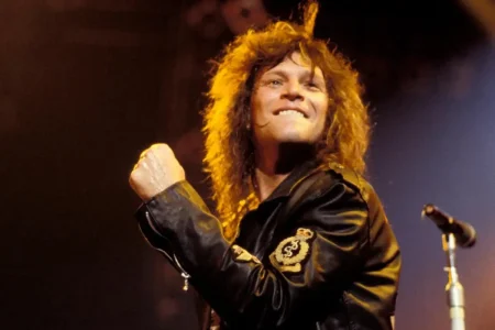 Jon Bon Jovi’s Most Dangerous Move: The Secret Vegas Wedding That Almost Broke His Career Jon Bon Jovi onstage in the 1980s, wearing a black leather jacket with patches.