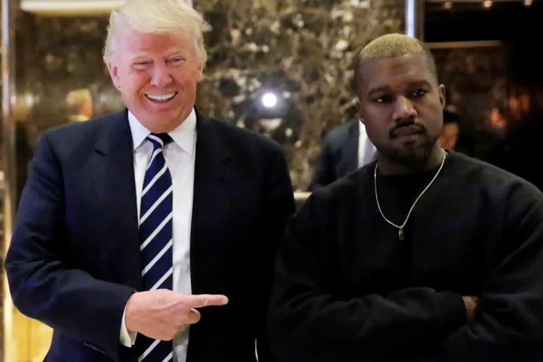 Kanye West and Donald Trump stand side by side in an indoor lobby area.