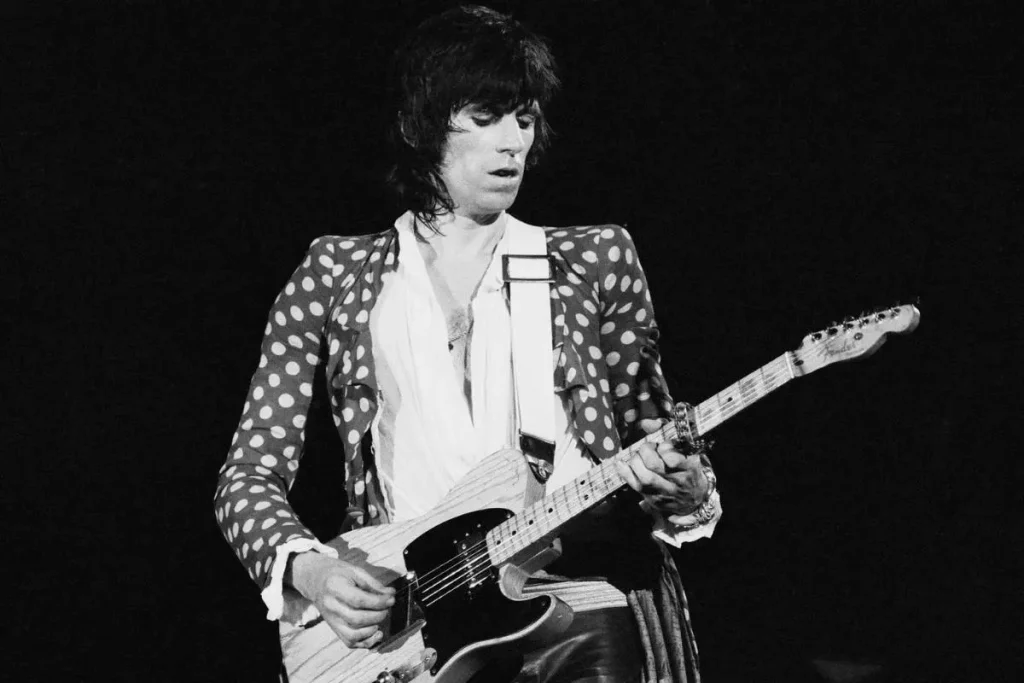 Keith Richards, Howlin’ Wolf and the Ghosts Who Built the Stones Keith Richards in a polka-dot jacket performs onstage, focused on his electric guitar during a live concert.