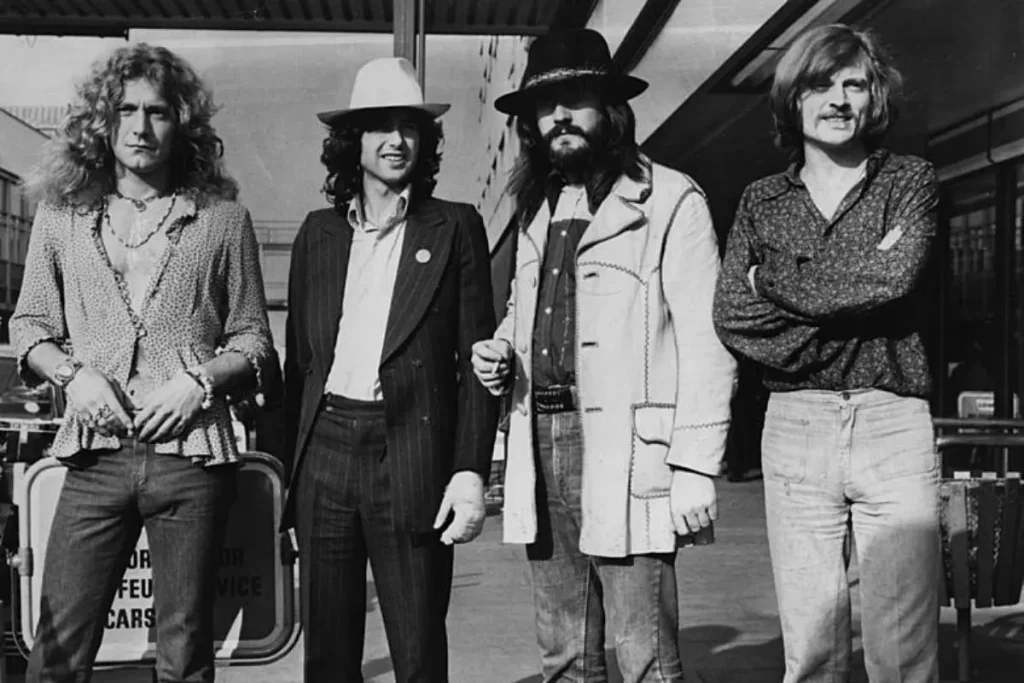 Led Zeppelin standing outside an airport terminal.