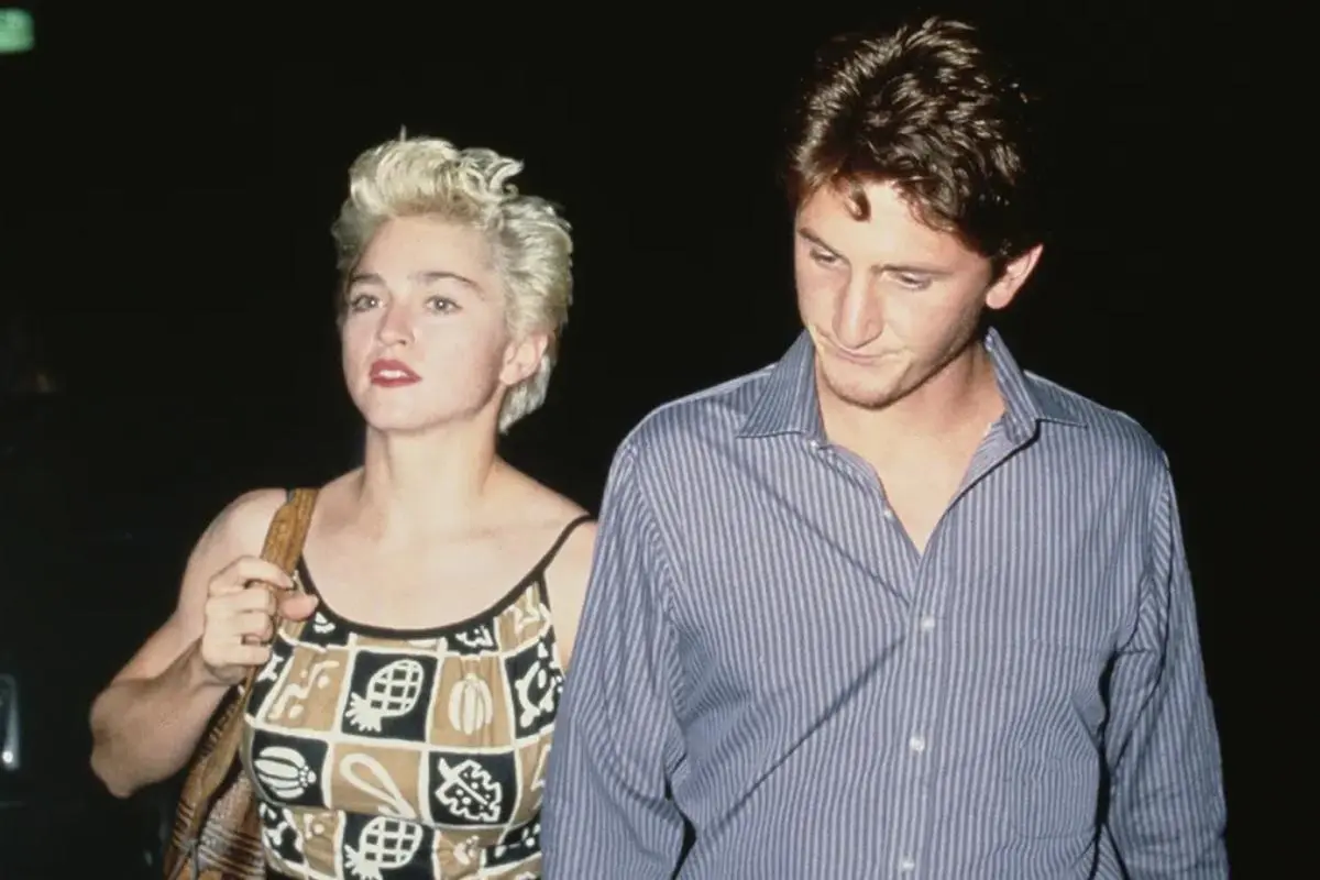 Madonna and Sean Penn walk side by side at night.
