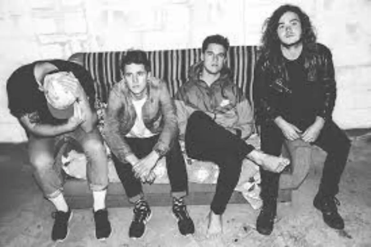 Single Band sitting casually on a couch in a black-and-white backstage-style photo.
