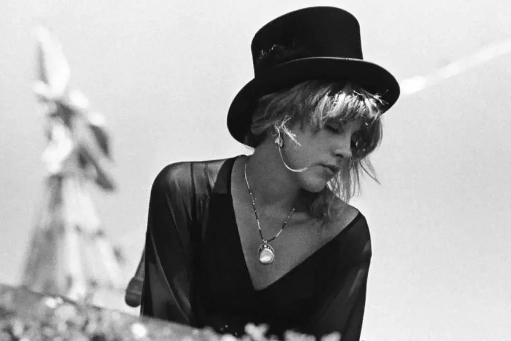 Stevie Nicks wearing a top hat and flowing outfit.