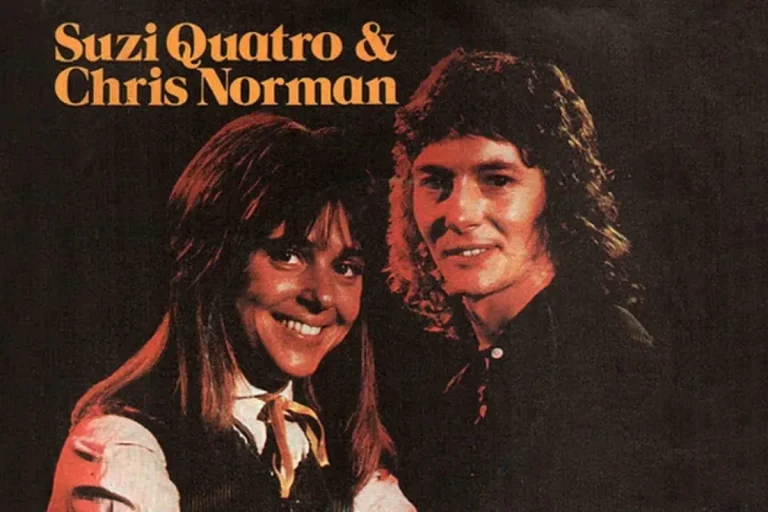 Suzi Quatro and Chris Norman posing together on a vintage album cover, smiling against a dark background.