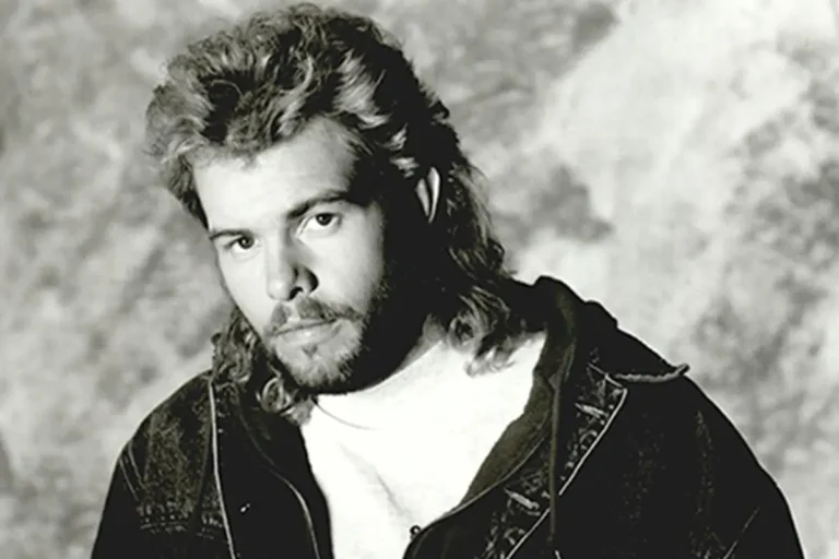 Inside Toby Keith’s “I’m Just Talkin’ About Tonight”: Honky-Tonk, Hookups & Legacy Tony Keith sings into a microphone while playing a red acoustic guitar during a live concert.