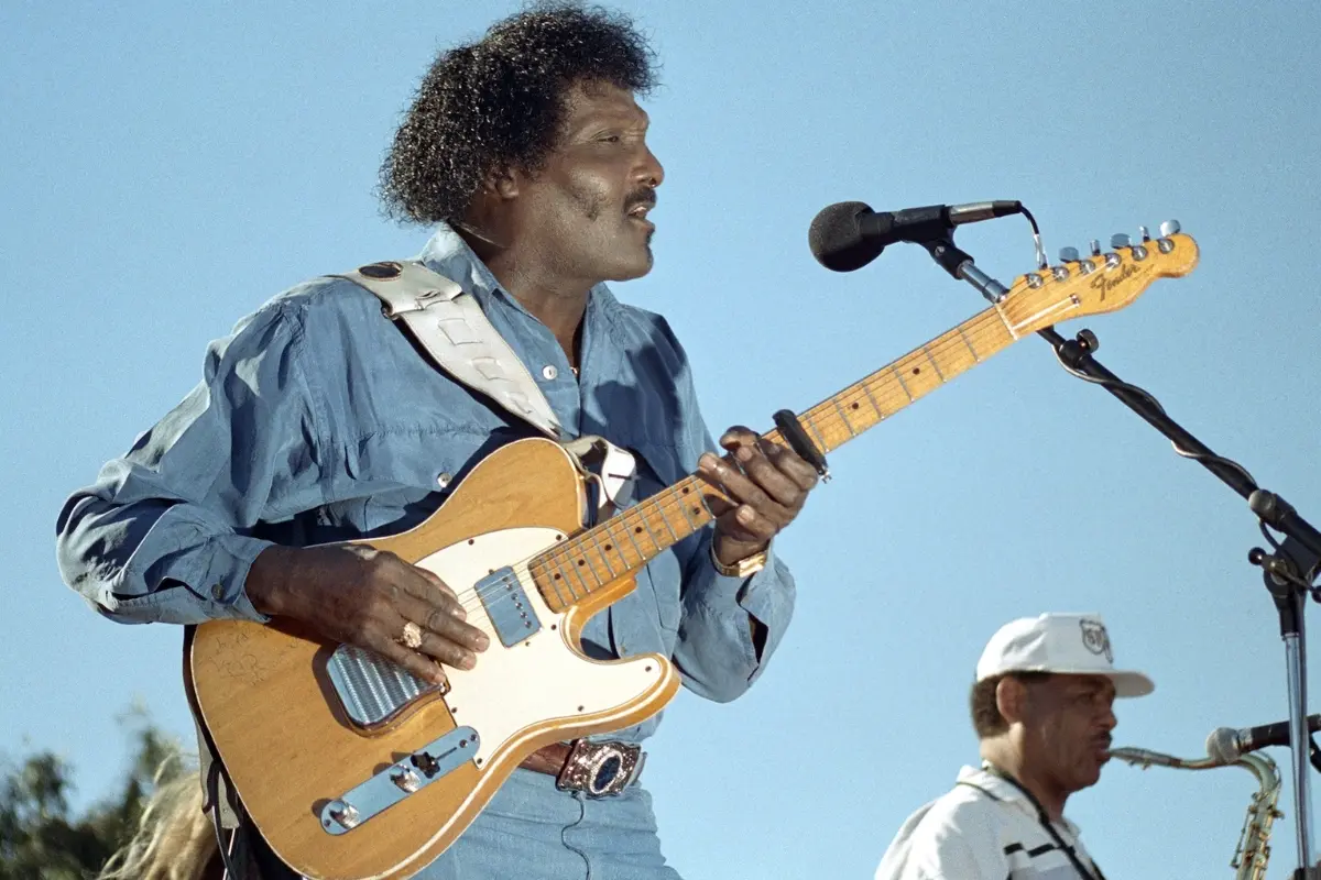 Playing under an open blue sky, the guitarist delivers his cutting tone with relaxed command, highlighting the blend of power, clarity, and showmanship that made his sound unmistakable.