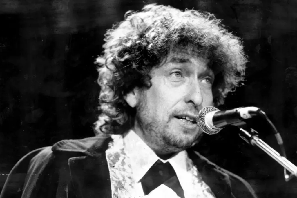 Bob Dylan captures an intense vocal performance, emphasizing expressive eyes, textured curls, and the raw emotional delivery of a timeless storyteller.