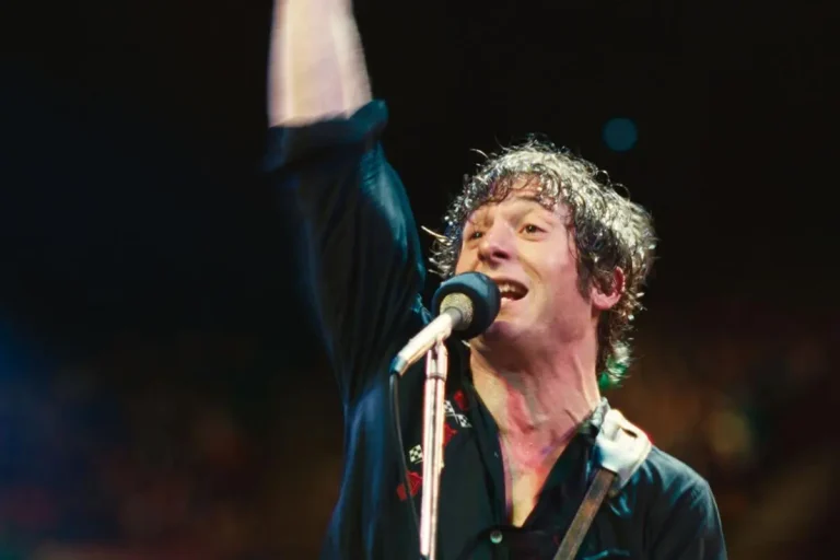 Bruce Springsteen’s The River: The Double Album That Refused to Behave Bruce Springsteen singing into a microphone, wearing a dark shirt under concert lighting.