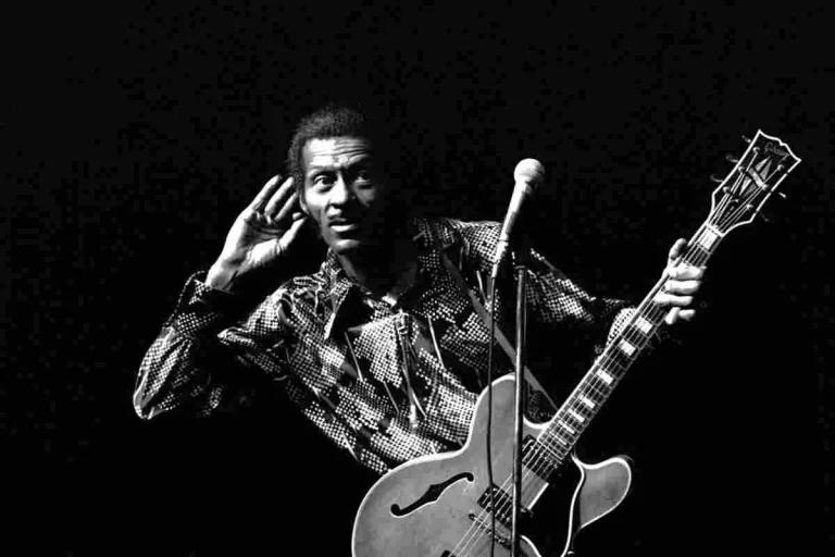Chuck Berry performing live on stage with electric guitar, black-and-white photo.