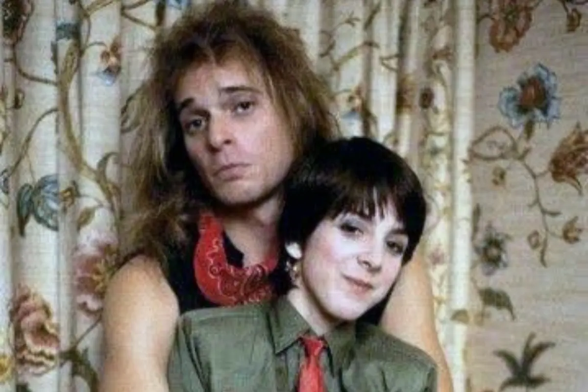David Lee Roth and Martha Quinn smiling toward the camera during a lively on-air interview, conveying pop culture energy and 1980s music television style.