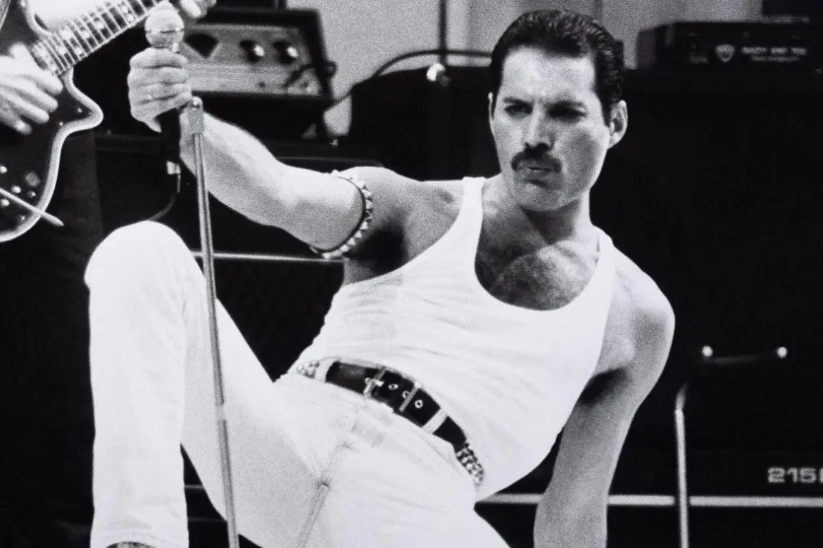 Freddie Mercury gripping a microphone stand during a live concert performance.