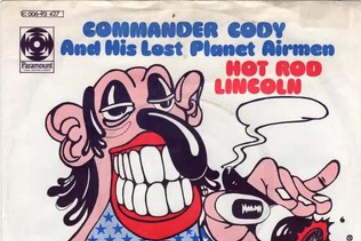 Hot Rod Lincoln thick black mustache and one hand pointing while smoke curls from a cigarette.