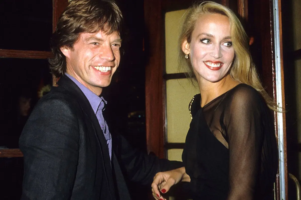 Mick Jagger and Jerry Hall attend a formal event together, smiling as they stand side by side in evening attire during a public appearance.