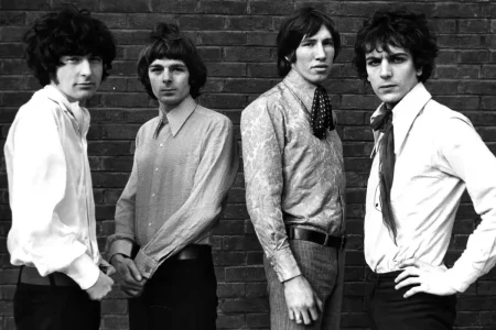 Pink Floyd members posing against a brick wall in a classic black-and-white photo.