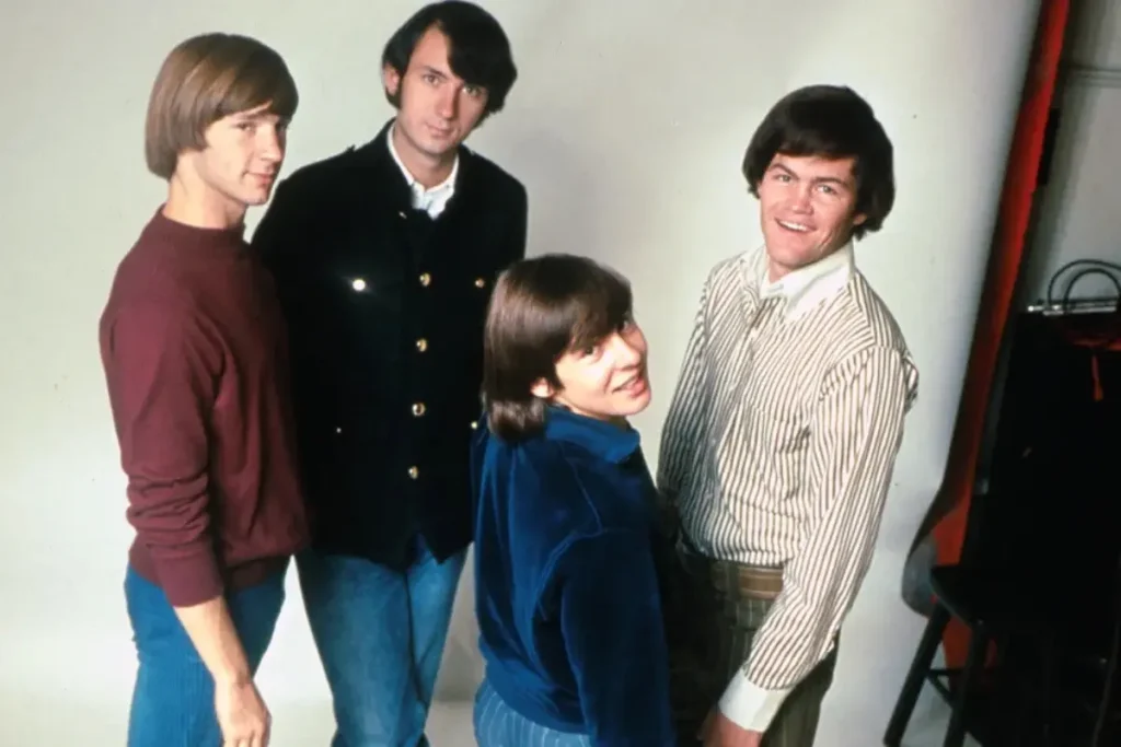 The Monkees pose together in a studio setting, highlighting their clean-cut image as a made-for-TV pop band at the start of their career.