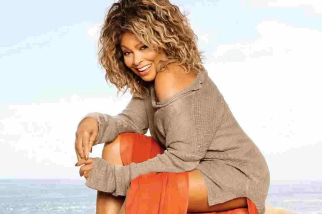 Tina Turner posing outdoors in a casual portrait, smiling at the camera.