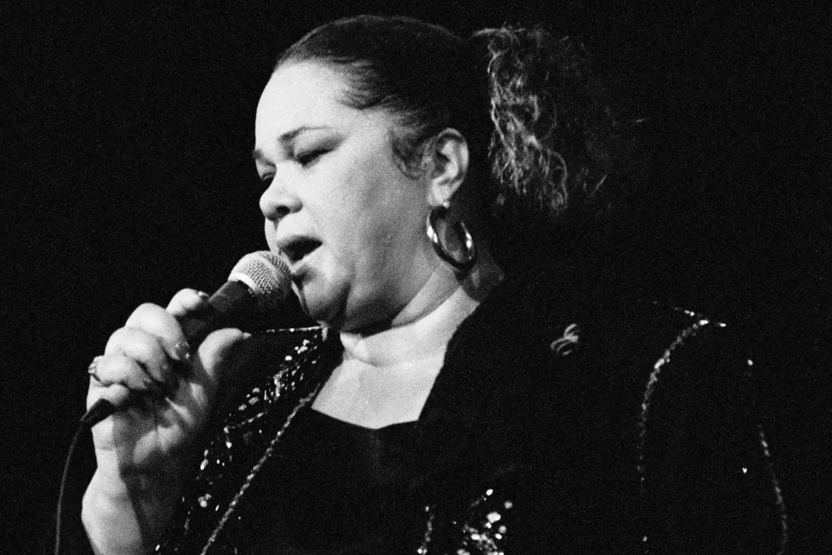 Etta James sings into a microphone during a live performance, conveying intensity and emotional depth that defined her soul and blues legacy.