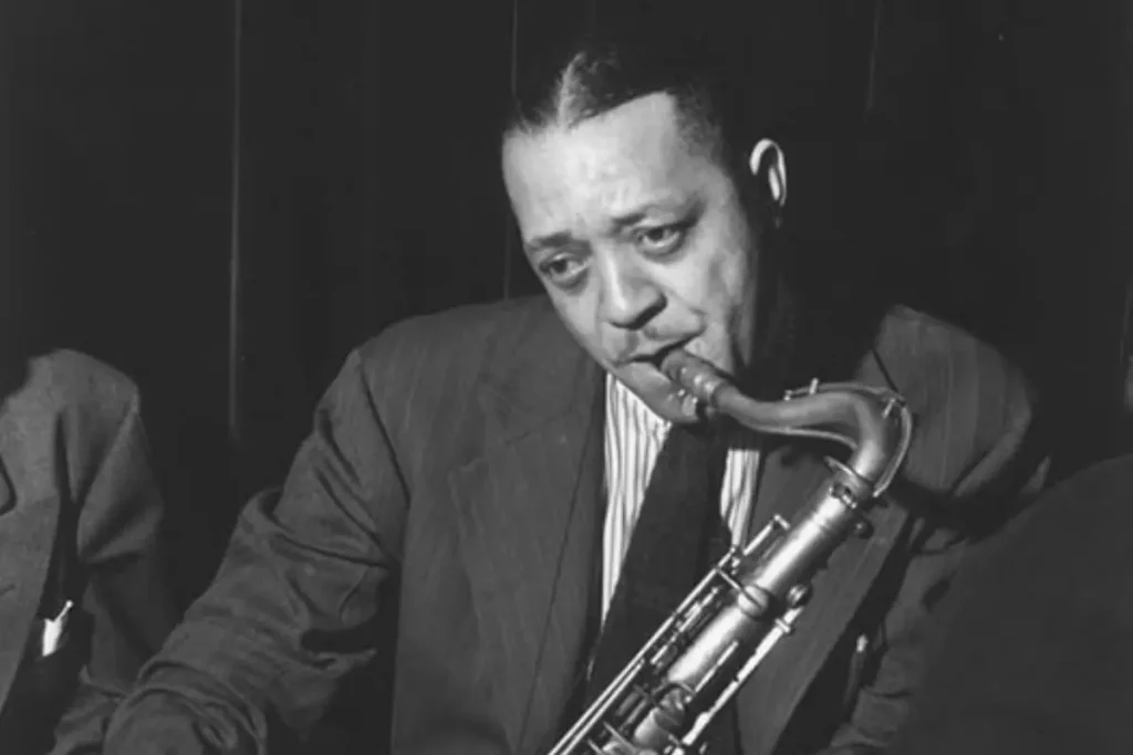 Lester Young: The Outsider Who Made Jazz Sound (and Look) Cool Lester young playing a tenor saxophone.
