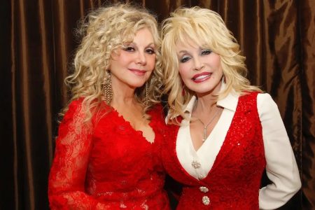 Dolly Parton Told Her Sister to Let Doctors Try Experimental Drugs on Her, Stella Parton Reveals Stella Parton and Dolly Parton, both dressed in red, stand cheek to cheek at Stella Parton's Red Tent Women's Conference in 2014