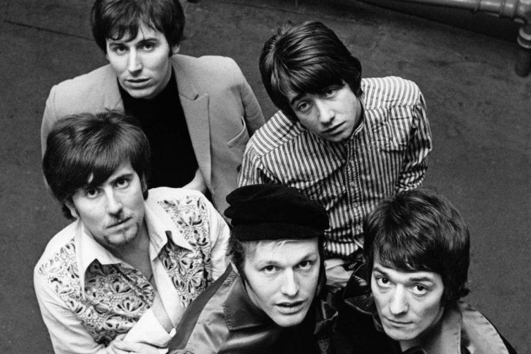 The Hollies Retire From Touring After 64 Years as Tony Hicks Steps Away for Health Reasons Black and white overhead photograph of the five members of The Hollies looking up at the camera in the 1960s