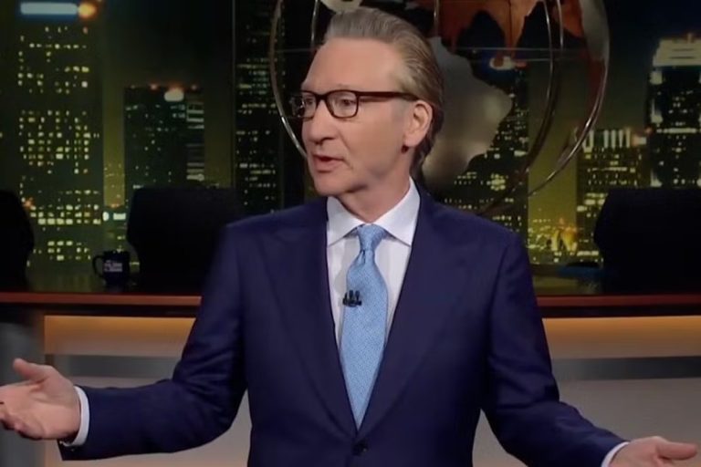 Bill Maher’s Dolly Parton Tribute Draws Criticism: What He Actually Said on ‘Real Time’ Bill Maher standing at his desk on the Real Time set, arms spread mid-monologue, with the Los Angeles skyline backdrop behind him