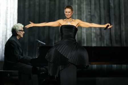Celine Dion Broke Down Onstage in Paris: ‘I Had Promised Myself Not to Cry’ Celine Dion stands with her arms outstretched on stage in a black pleated gown, visibly emotional, with her pianist at a grand piano behind her
