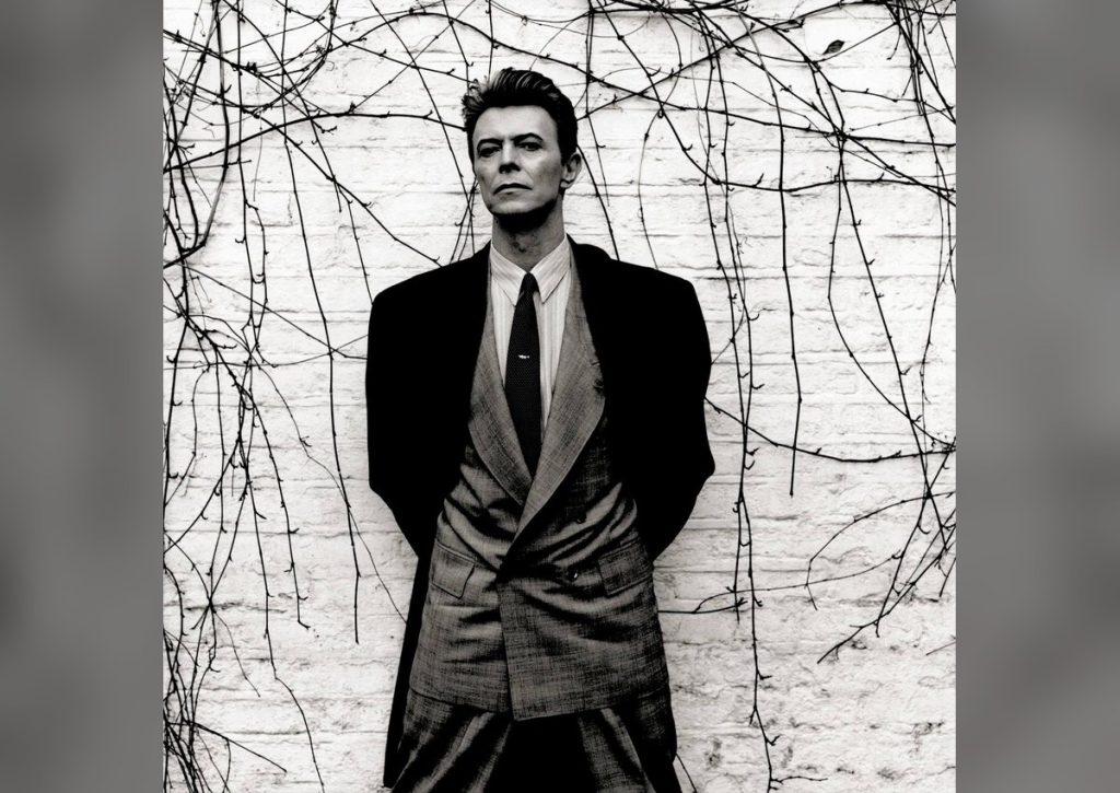 David Bowie in a suit against a bare backdrop