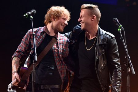 Ed Sheeran Breaks His Silence on Macklemore’s Tour Removal: “I Am Not Complicit” Ed Sheeran and Macklemore laughing together on stage, Sheeran holding an acoustic guitar