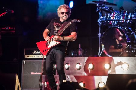 Sammy Hagar Answers Alex Van Halen’s ‘Complete Idiot’ Jab: ‘The Truth Hurts Sometimes’ Sammy Hagar performing on stage with a red Gibson Explorer guitar